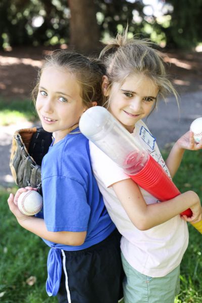 Two Girls Holding Baseball Softball Gear at Dream Big Summer Day Camp | Hilltop Denver and Greenwood Village