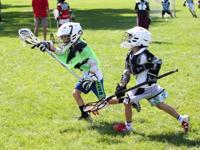 Kids Running Playing Lacrosse in Field at Dream Big Summer Day Camp | Hilltop Denver and Greenwood Village