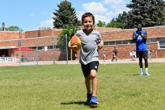 Kid Running with Football at Dream Big Summer Day Camp | Hilltop Denver and Greenwood Village